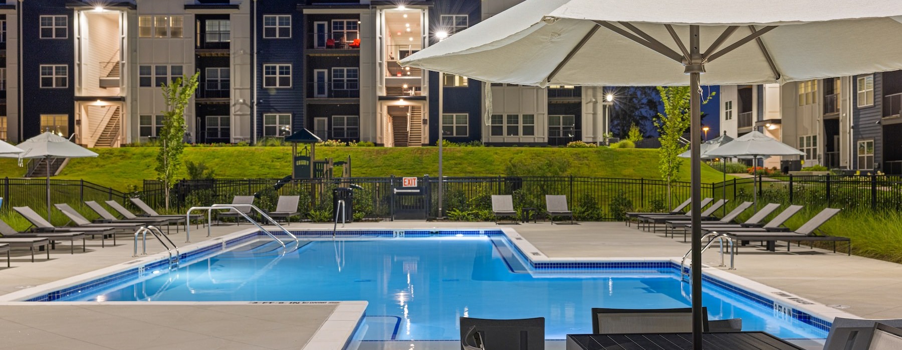 a pool with a lounge chair and umbrella by it