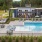 a swimming pool with chairs and umbrellas next to it